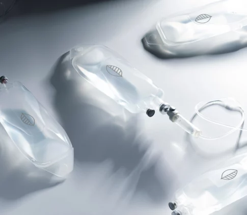 Multiple clear intravenous (IV) drip bags and tubing laid out on a clean, modern surface.